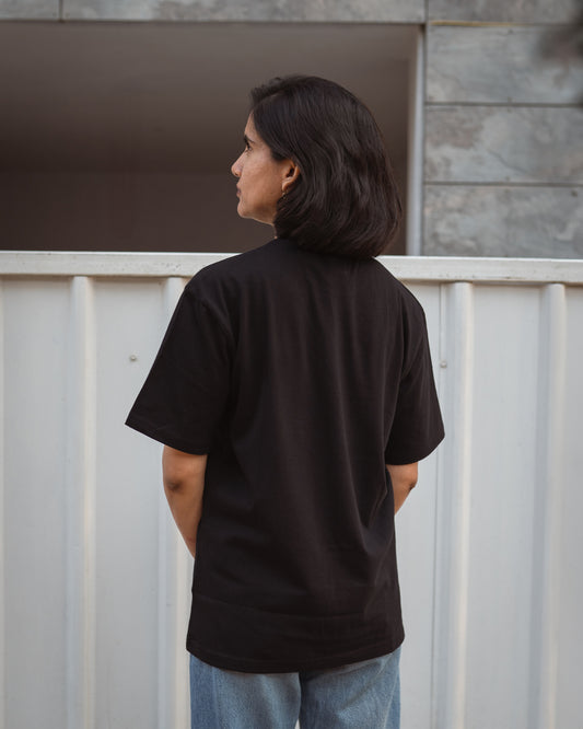 Back view of woman wearing black organic cotton T-shirts from 2512 Pacchis Barah — crafted as sustainable t-shirts and eco friendly t-shirts that blend simplicity and comfort. This versatile organic cotton tee is a perfect unisex choice from the men’s organic cotton t shirts and organic t shirts women line.