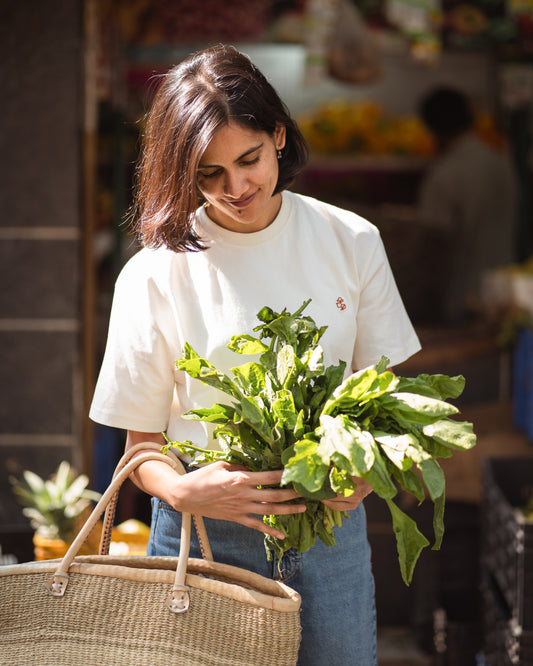 Model standing outdoors in white tee, soft light styling