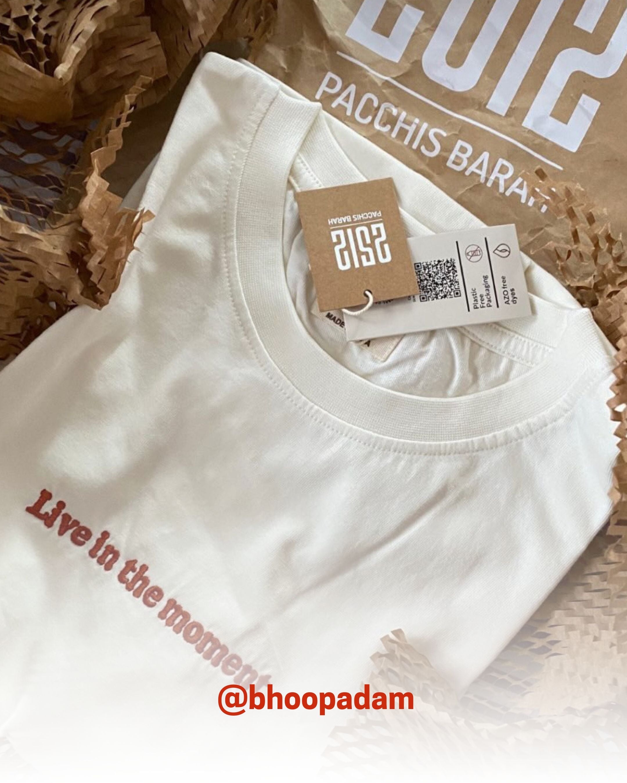White organic cotton T-Shirt with 'Live in the moment' text, packed with 2512 branding tags, showcasing sustainable t-shirts and eco friendly fashion.