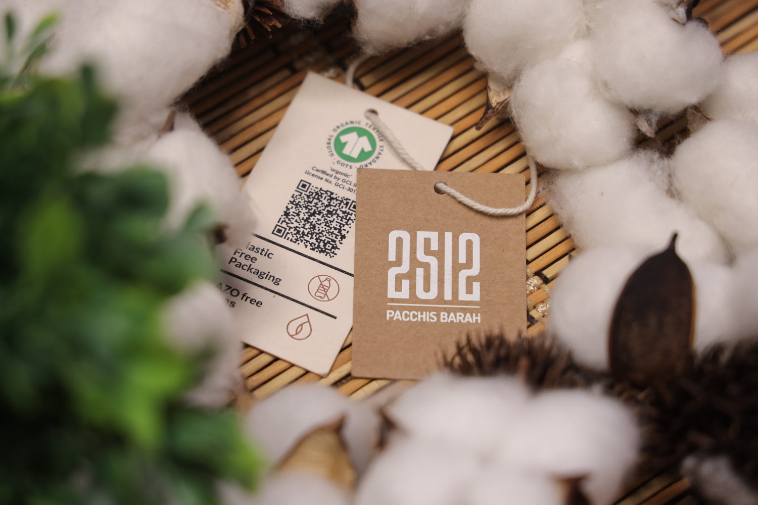 2512 Pacchis Barah clothing tag with eco friendly packaging surrounded by cotton, representing the brand’s commitment to organic cotton t-shirts, sustainable t-shirts, and eco friendly t-shirts designed for unisex wear.